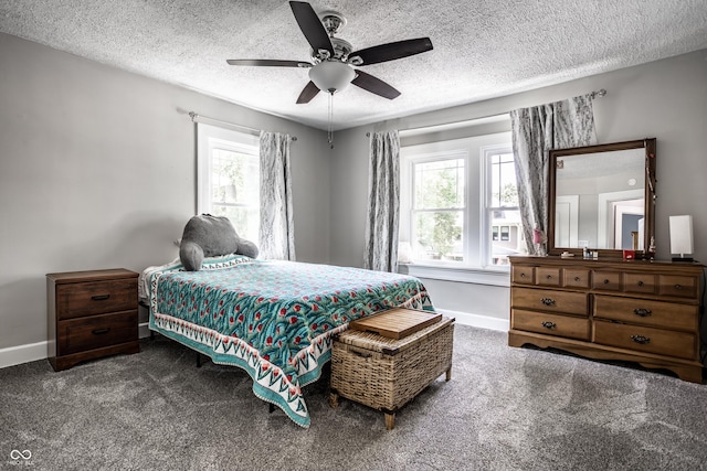 carpeted bedroom with ceiling fan and a textured ceiling