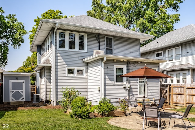 back of property featuring a storage shed, a lawn, a patio, and central air condition unit