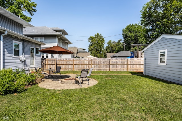 view of yard featuring an outbuilding, a patio, and an outdoor fire pit