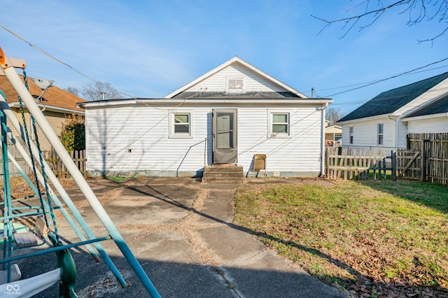 rear view of house featuring a lawn and a patio area