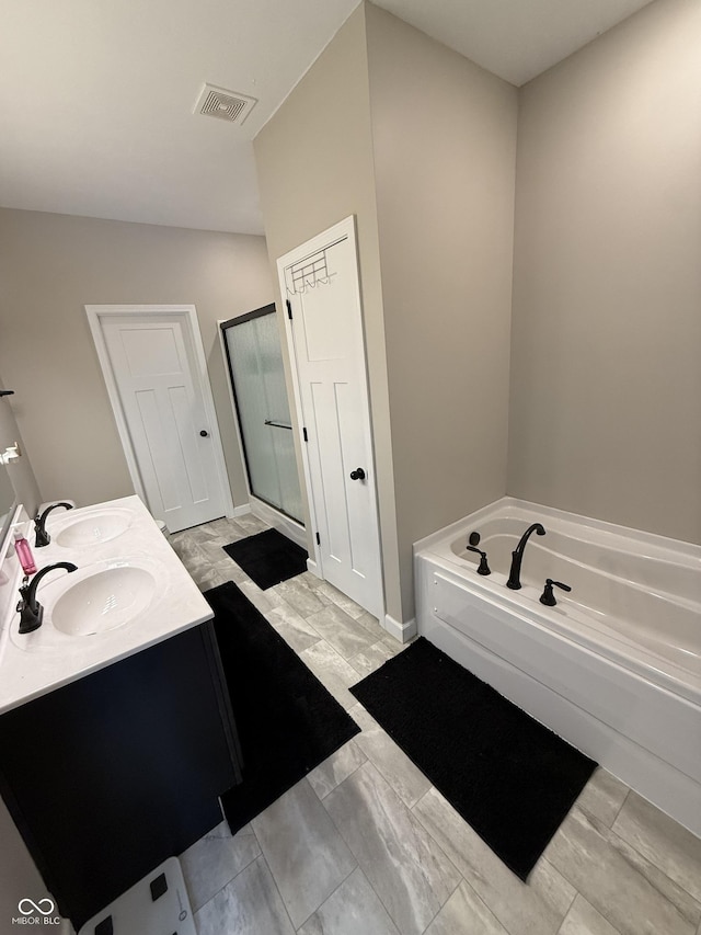 bathroom with vanity and shower with separate bathtub