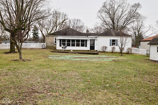 rear view of house with a sunroom and a yard