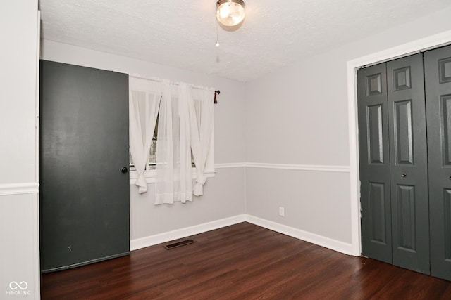 interior space with dark hardwood / wood-style flooring and a textured ceiling