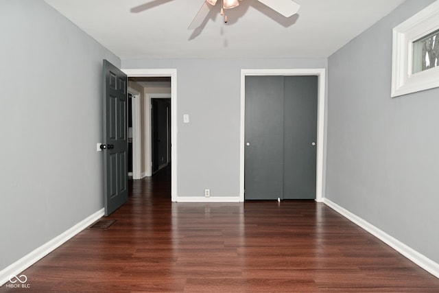 unfurnished bedroom with dark wood-type flooring, ceiling fan, and a closet