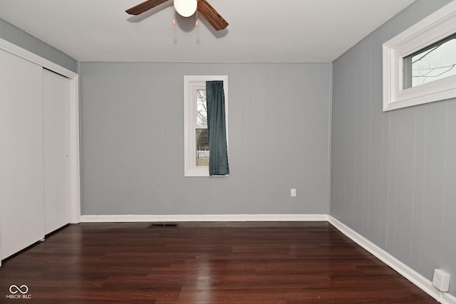 unfurnished bedroom with ceiling fan, dark hardwood / wood-style floors, and a closet