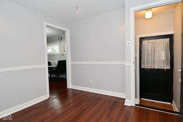 foyer entrance featuring dark hardwood / wood-style floors and a textured ceiling