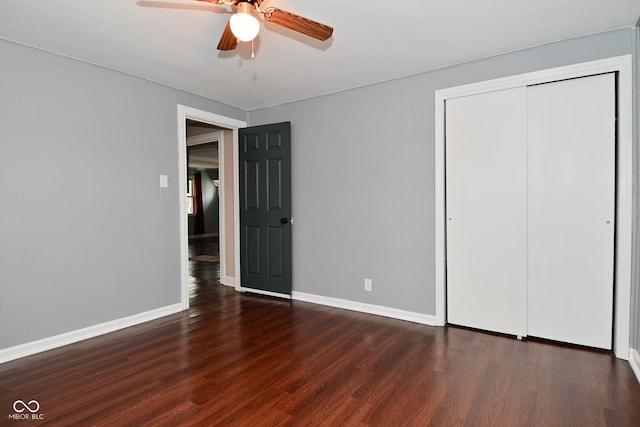 unfurnished bedroom with dark hardwood / wood-style flooring, a closet, and ceiling fan