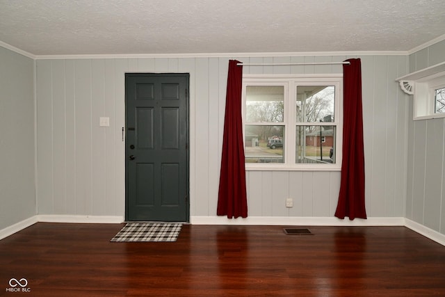 foyer entrance with ornamental molding, hardwood / wood-style floors, and a textured ceiling