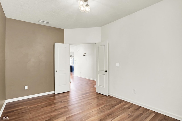 empty room featuring hardwood / wood-style flooring and a textured ceiling