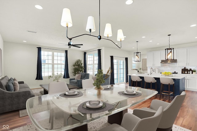 dining space featuring hardwood / wood-style flooring, ceiling fan, and sink