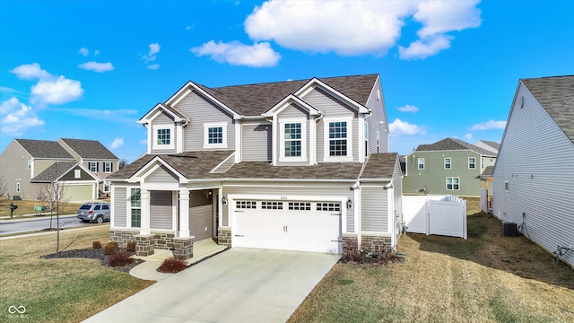 view of front of property featuring cooling unit, a garage, and a front lawn