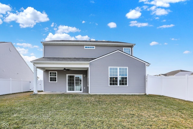 rear view of property featuring ceiling fan, a patio area, and a lawn