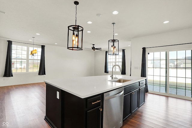 kitchen with pendant lighting, sink, dishwasher, a kitchen island with sink, and wood-type flooring