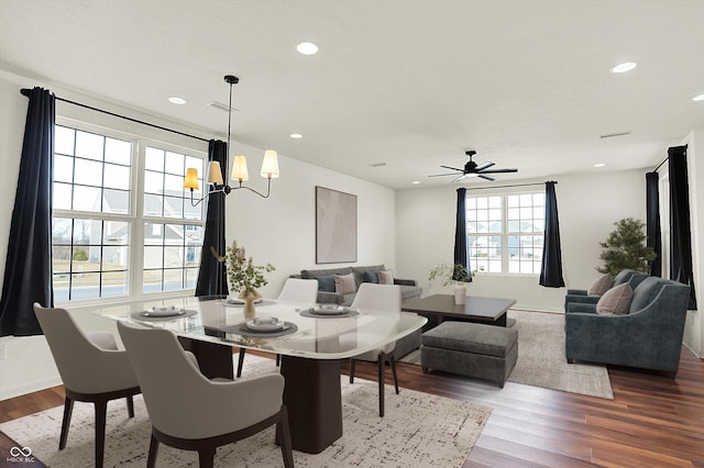 dining space featuring ceiling fan with notable chandelier and hardwood / wood-style floors