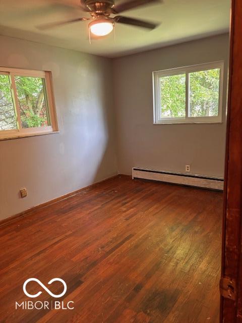 79 Circle Dr, Mooresville, IN 46158 - spare room with plenty of natural light, ceiling fan, a baseboard heating unit, and dark wood finished floors