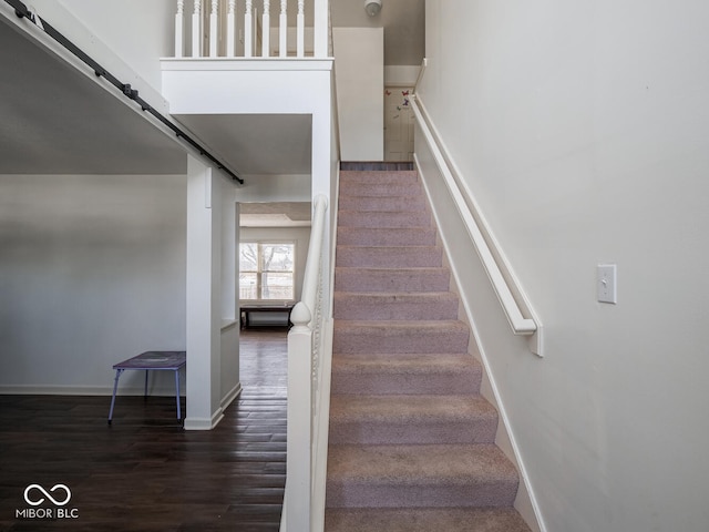 stairs with wood-type flooring and a barn door