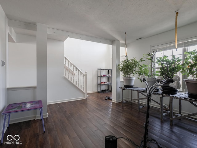 interior space with dark wood-type flooring and a textured ceiling