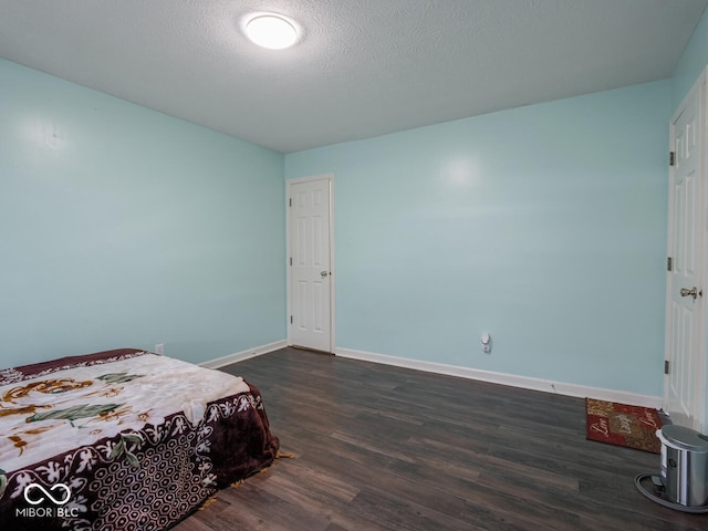 bedroom with dark hardwood / wood-style flooring and a textured ceiling