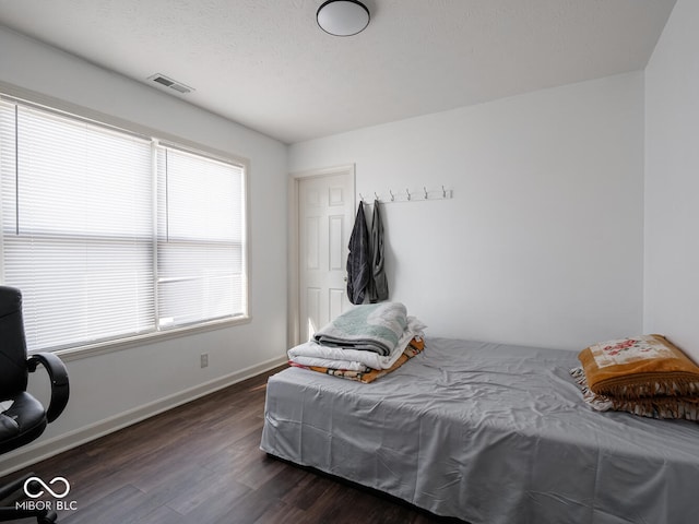 bedroom with dark wood-type flooring and a textured ceiling