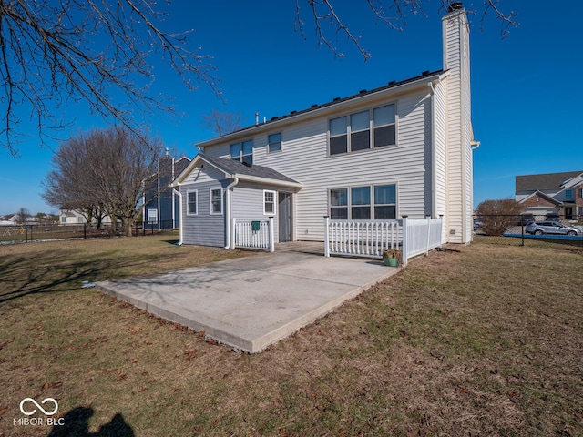 back of property with a yard and a patio area