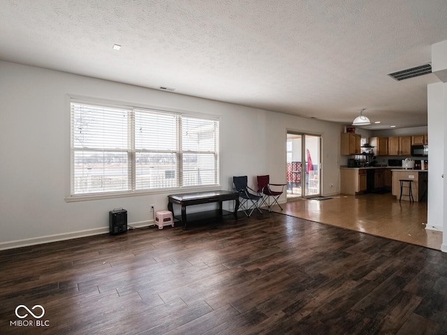 unfurnished living room featuring dark hardwood / wood-style floors and a textured ceiling