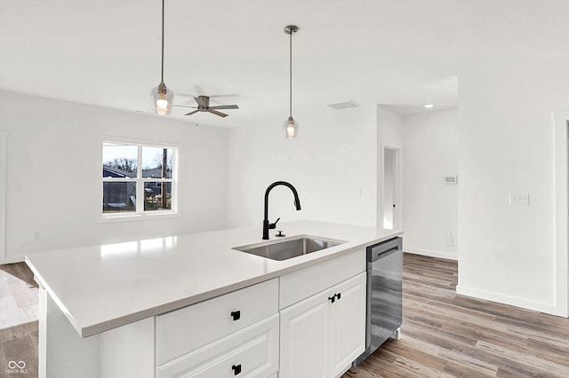 kitchen featuring pendant lighting, sink, white cabinets, a kitchen island with sink, and stainless steel dishwasher