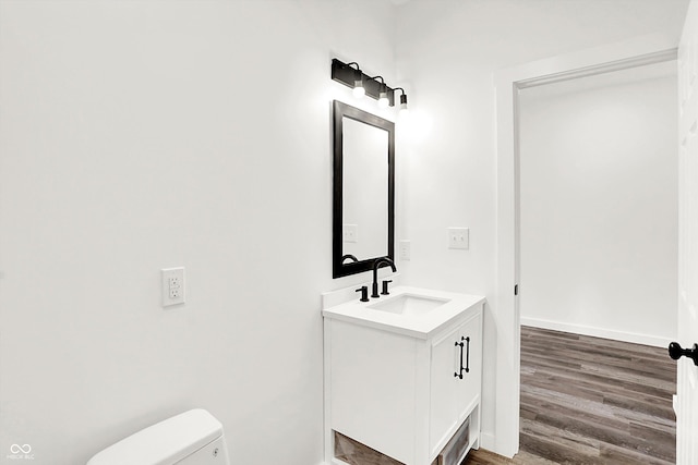 bathroom with vanity, hardwood / wood-style floors, and toilet