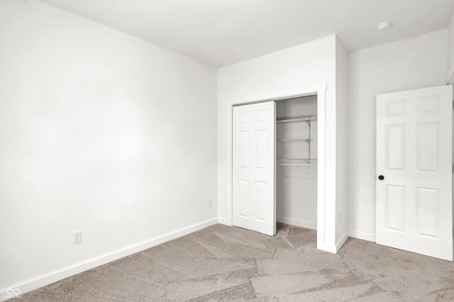 unfurnished bedroom featuring carpet and a closet