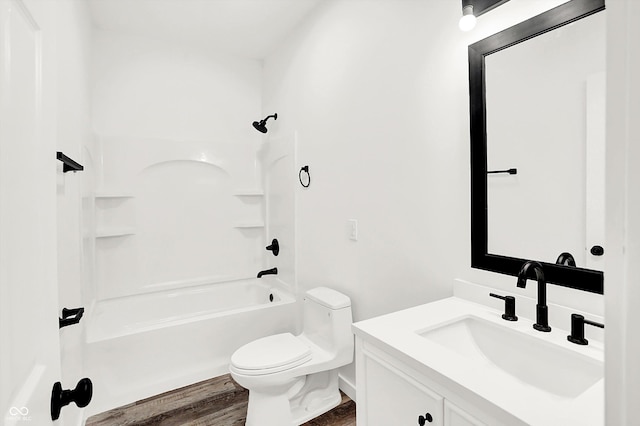 full bathroom featuring vanity, hardwood / wood-style floors, washtub / shower combination, and toilet