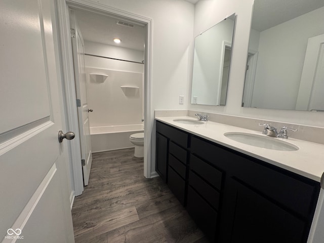 full bathroom with hardwood / wood-style flooring, shower / tub combination, vanity, and toilet