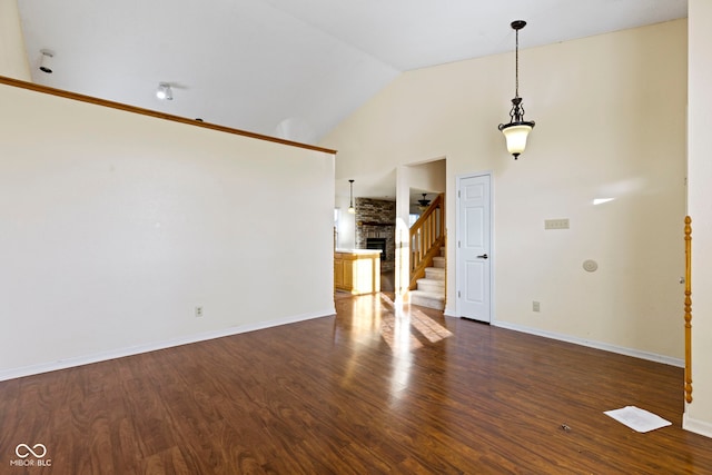 unfurnished living room with dark hardwood / wood-style flooring and high vaulted ceiling