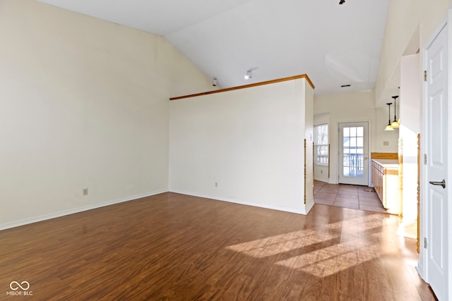 unfurnished living room featuring lofted ceiling and wood-type flooring