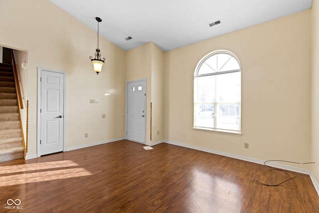 foyer with hardwood / wood-style flooring and high vaulted ceiling