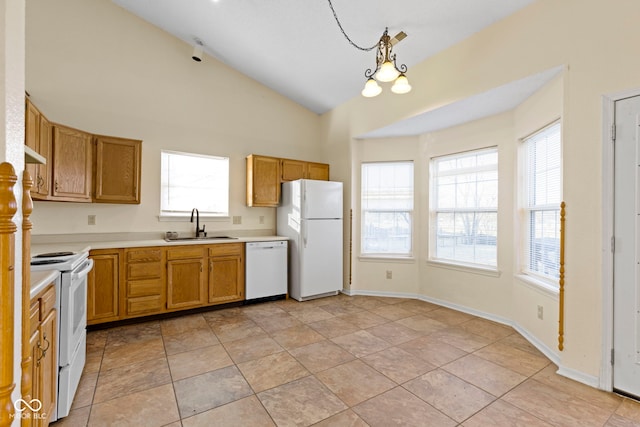 kitchen featuring lofted ceiling, sink, hanging light fixtures, light tile patterned floors, and white appliances