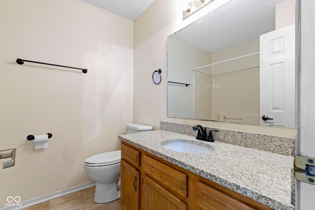 bathroom with tile patterned flooring, vanity, toilet, and walk in shower