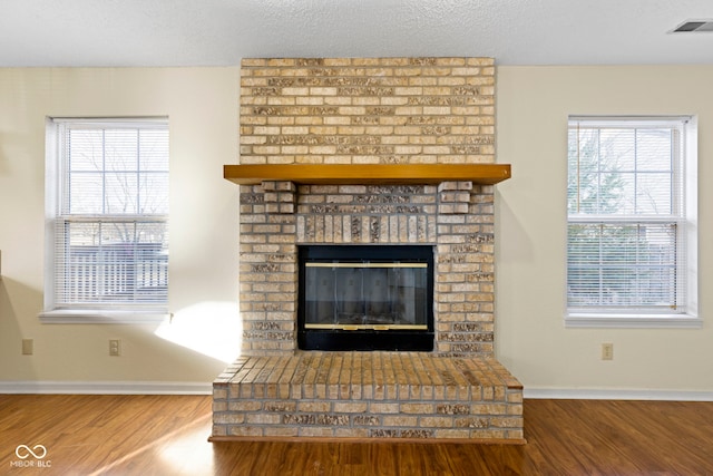 interior details with hardwood / wood-style floors, a fireplace, and a textured ceiling