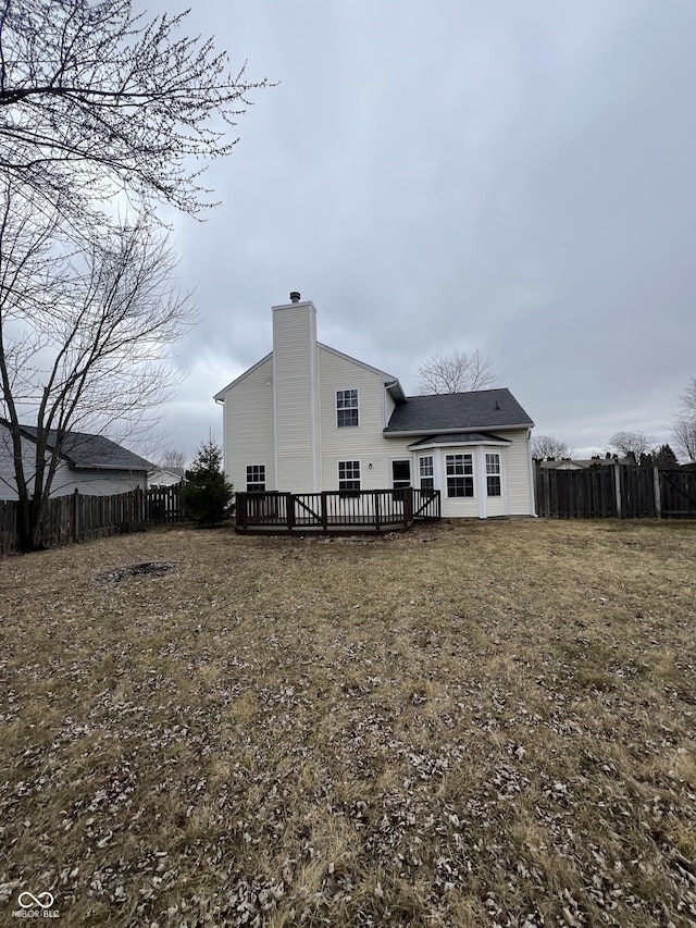 rear view of house with a wooden deck and a yard