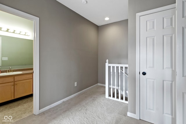 2231 Colfax Ln, Indianapolis, IN 46260 - hallway with a sink, an upstairs landing, baseboards, and light colored carpet