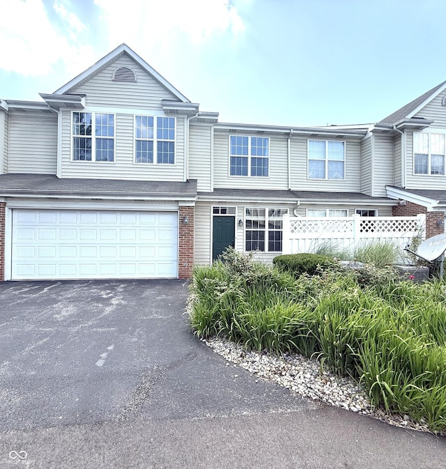 2231 Colfax Ln, Indianapolis, IN 46260 - townhome / multi-family property with an attached garage, driveway, and brick siding