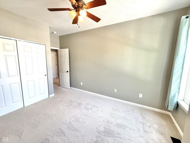 2231 Colfax Ln, Indianapolis, IN 46260 - unfurnished bedroom with light carpet, a closet, and a ceiling fan