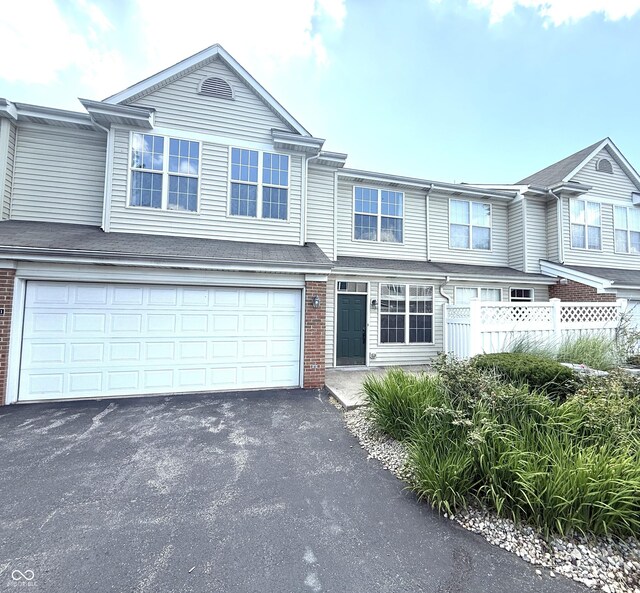 2231 Colfax Ln, Indianapolis, IN 46260 - townhome / multi-family property featuring brick siding, asphalt driveway, and an attached garage