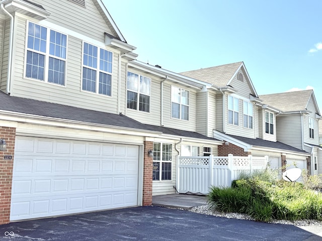 2231 Colfax Ln, Indianapolis, IN 46260 - townhome / multi-family property featuring driveway, an attached garage, and brick siding
