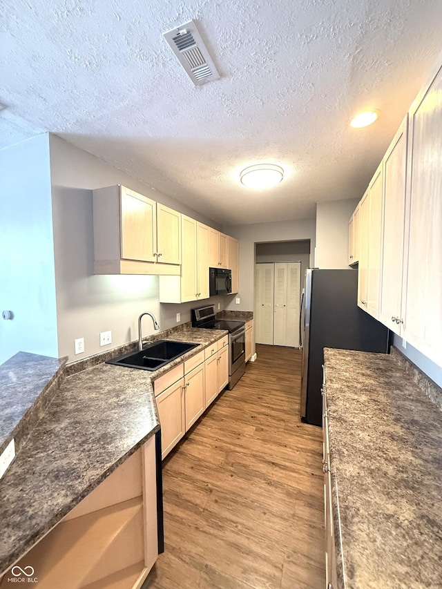 2231 Colfax Ln, Indianapolis, IN 46260 - kitchen with appliances with stainless steel finishes, light wood-style flooring, a textured ceiling, and recessed lighting