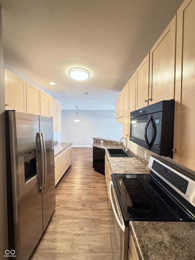 2231 Colfax Ln, Indianapolis, IN 46260 - kitchen featuring black appliances, light wood-type flooring, a textured ceiling, and light brown cabinetry