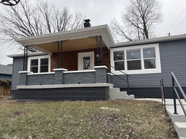 view of front facade with a front yard and covered porch