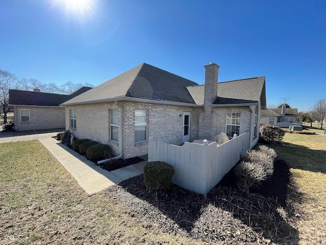 5850 Bradston Way, Indianapolis, IN 46237 - view of home's exterior featuring brick siding, a yard, a chimney, and roof with shingles