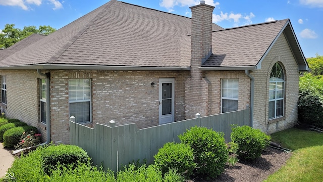 5850 Bradston Way, Indianapolis, IN 46237 - view of side of property featuring roof with shingles, a chimney, and brick siding