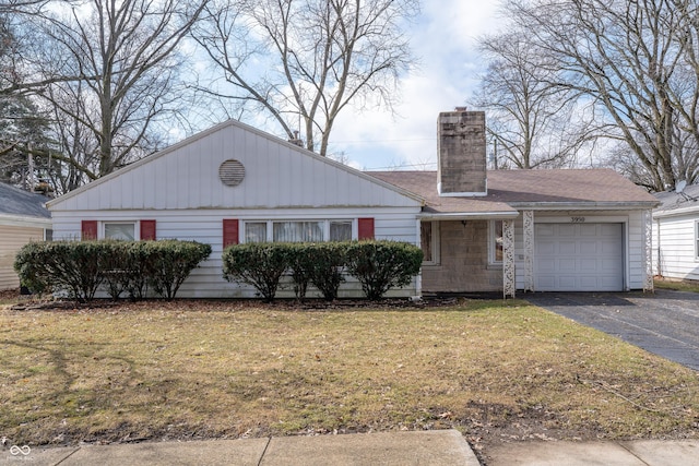 view of front of property featuring driveway, a chimney, roof with shingles, an attached garage, and a front yard