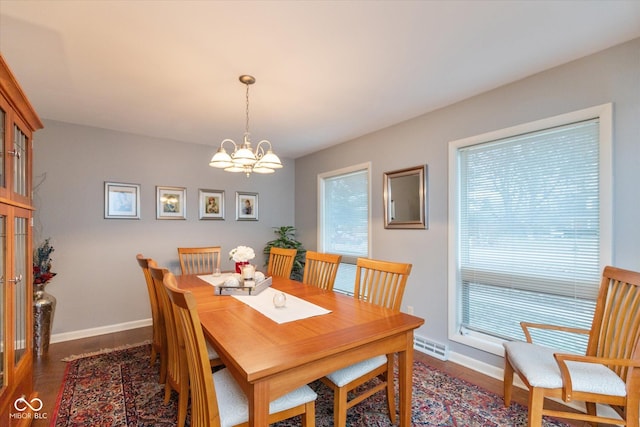 dining area featuring an inviting chandelier and dark hardwood / wood-style flooring