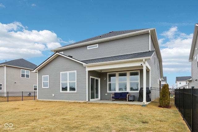 back of property with a lawn and a patio area